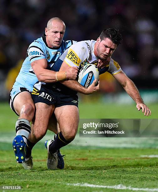 Lachlan Coote of the Cowboys is tackled by Jeff Robson of the Sharks during the round 16 NRL match between the North Queensland Cowboys and the...