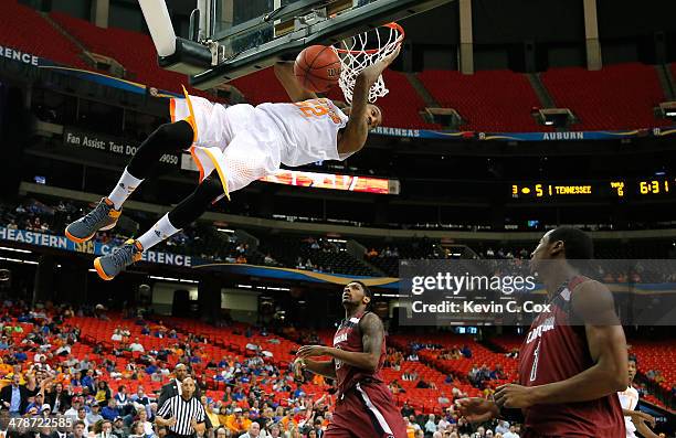 Jordan McRae of the Tennessee Volunteers dunks against Sindarius Thornwell and Brenton Williams of the South Carolina Gamecocks against during the...
