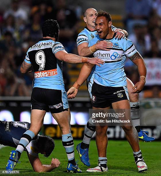 Sam Tagataese of the Sharks celebrates after scoring a try with Jeff Robson and Michael Ennis of the Sharks during the round 16 NRL match between the...