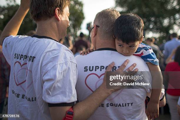 Mark Beckfold and Steve Ledoux , who are married, hold their foster son at a celebration of the Supreme Court ruling on same-sex marriage on June 26,...