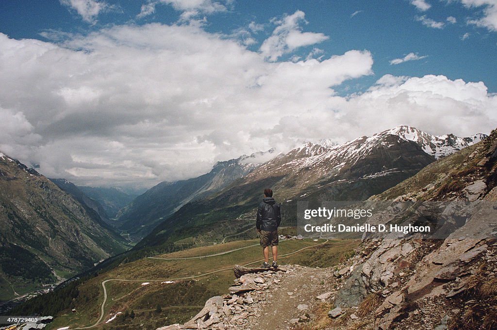 Hiker Standing On Trail In Swiss Alps
