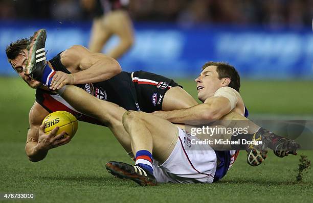 Maverick Weller of the Saints is tackled by Dale Morris of the Bulldogs during the round 13 AFL match between the St Kilda Saints and the Western...