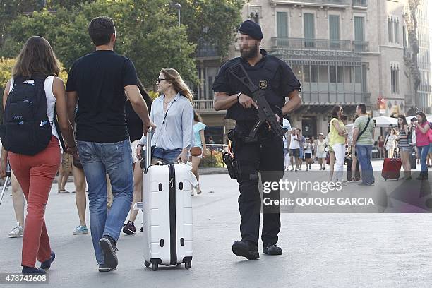 Catalan policeman patrols at Plaza Catalunya in Barcelona on June 26, 2015. Spain raised its terror alert level from medium to high tofay after...