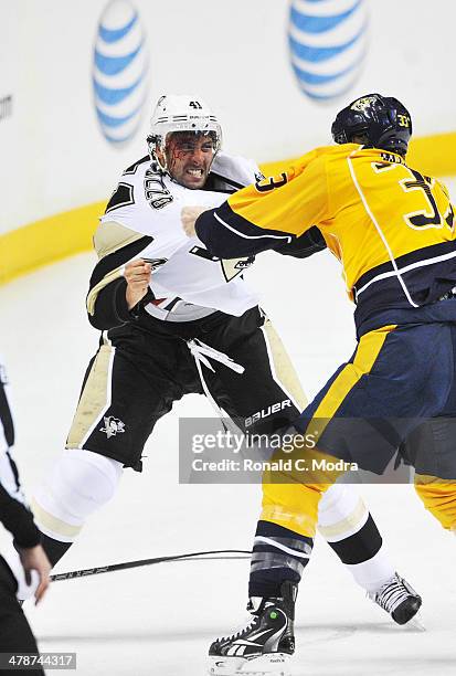 Robert Bortuzzo of the Pittsburgh Penguins fights Colin Wilson of the Nashville Predators at Bridgestone Arena on March 4, 2014 in Nashville,...