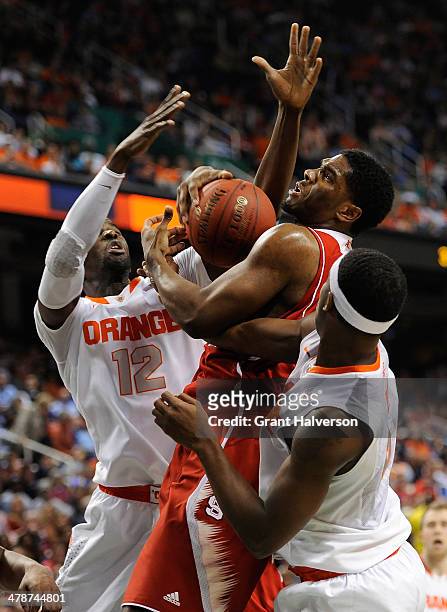 Baye Keita and C.J. Fair of the Syracuse Orange battle for a rebound with Lennard Freeman of the North Carolina State Wolfpack during the...