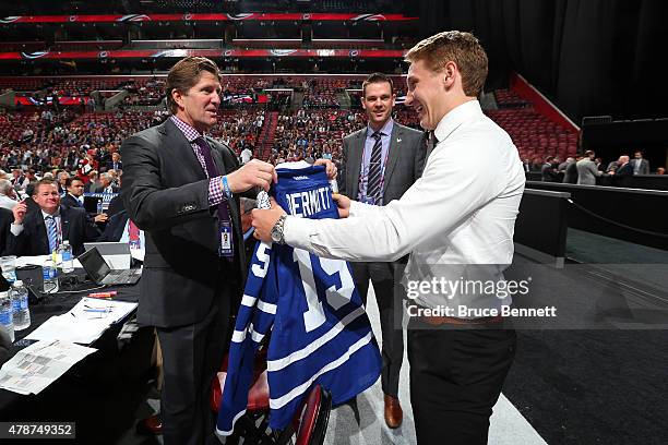 Travis Dermott talks with head coach Mike Babcock after being selected 34th by the of the Toronto Maple Leafs during the 2015 NHL Draft at BB&T...