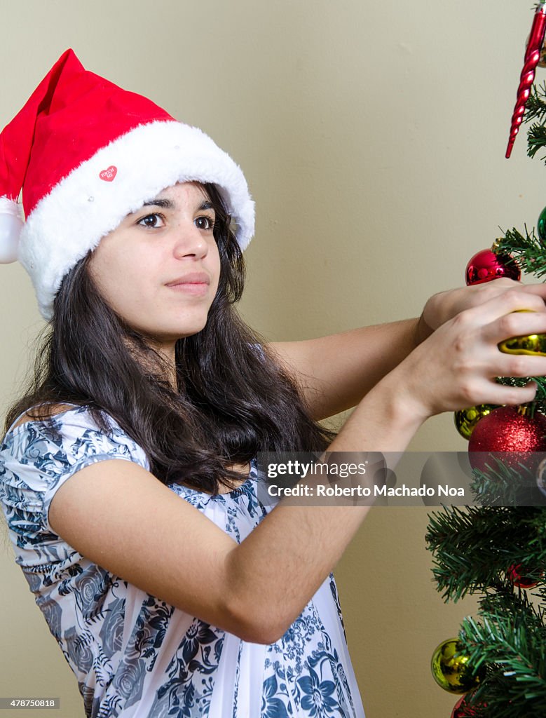 Real life Christmas Holiday scenes: Young Hispanic girl in a...