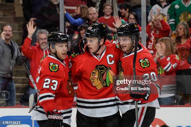 Jonathan Toews of the Chicago Blackhawks reacts with teammates Kris Versteeg and Brandon Saad after scoring against the Nashville Predators in the...