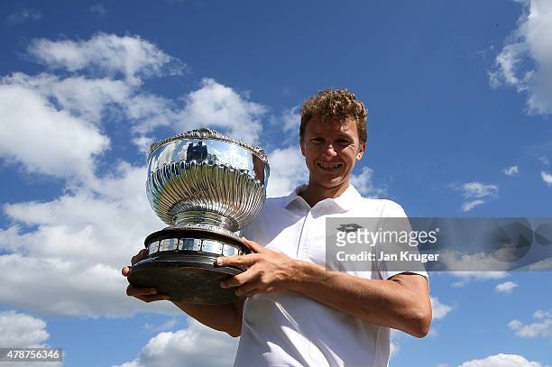 Denis Istomin of Uzbekistan poses with the trophy after victory over Sam Querrey of the United States during the mens singles final match on day...