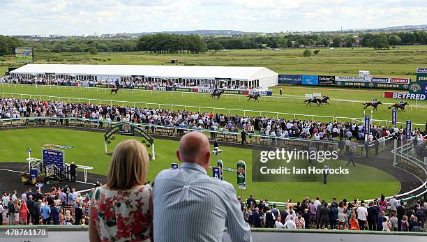 Spectators watch on as Gerry The Glover ridden by Silvestra De Sousa wins the The Betfred Keep it Funny Handicap Stakes during The Northumberland...