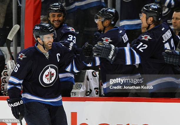 Andrew Ladd of the Winnipeg Jets gets congratulated at the bench after scoring a first period goal against the New York Rangers at the MTS Centre on...