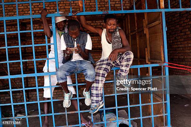 Men rest on a fence in a market on June 27, 2015 in Bujumbura, Burundi. Burundi is one of the worlds poorest countries with food shortages throughout...
