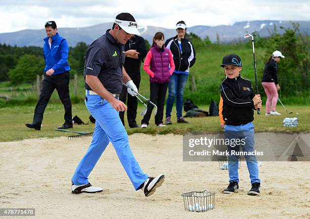 Riccardo Gouveia of Portugal giving local children a bunker lesson during the third round of the 2015 SSE Scottish Hydro Challenge at the MacDonald...