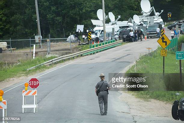 Media vehicles set up near a police roadblock near the perimeter of a wooded area where they believe escaped convict David Sweat may be hiding on...