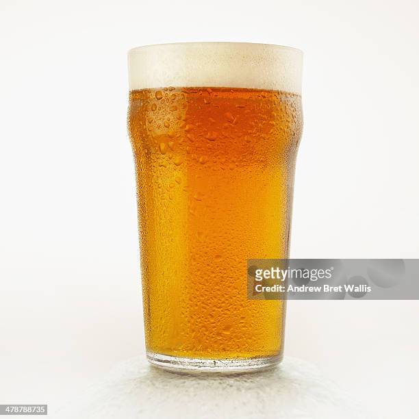 pint glass of chilled light beer with condensation - glas bier stockfoto's en -beelden