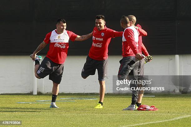 Chile's players Gary Medel , Gonzalo Jara and Arturo Vidal stretch during a training session at the Juan Pinto Duran sports complex in Santiago, on...