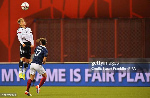 Babett Peter of Germany is challenged by Gaetane Thiney of France during the quarter final match of the FIFA Women's World Cup between Germany and...