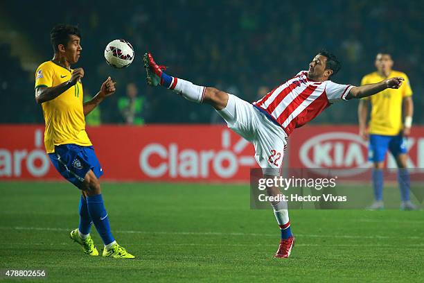 Eduardo Aranda of Paraguay fights for the ball with Roberto Firmino of Brazil during the 2015 Copa America Chile quarter final match between Brazil...