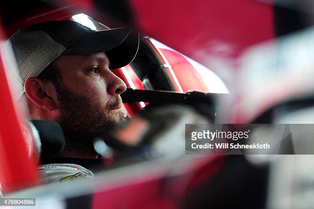 Bobby Santos, driver of the Tinio Corp/Dan Kelley/Curb Records Chevrolet, sits in his car in the garage area during practice for the NASCAR Whelen...