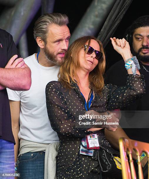 Stella McCartney and Alasdhair Willis watch from side of stage at the Glastonbury Festival at Worthy Farm, Pilton on June 27, 2015 in Glastonbury,...