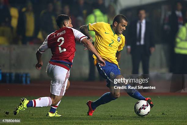 Dani Alves of Brazil fights for the ball with Ivan Piris of Paraguay during the 2015 Copa America Chile quarter final match between Brazil and...