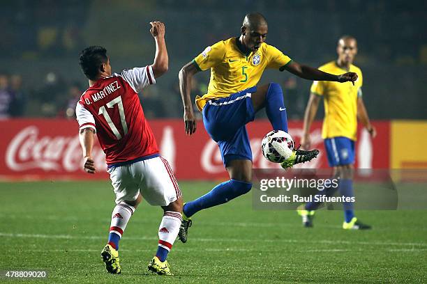 Fernandinho of Brazil fights for the ball with Osvaldo Martinez of Paraguay during the 2015 Copa America Chile quarter final match between Brazil and...