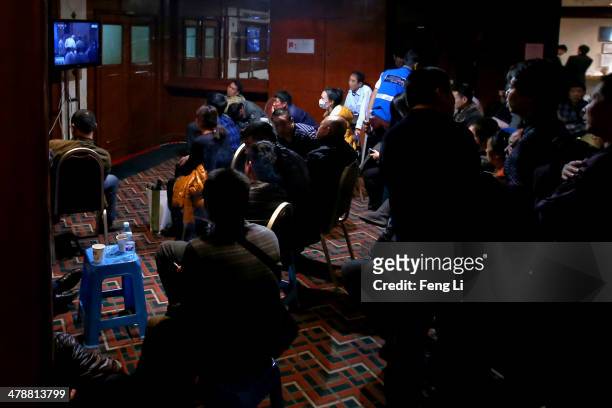 Chinese relatives of the missing passengers who were travelling onboard Malaysia Airlines flight MH370 watch a television displaying a press...