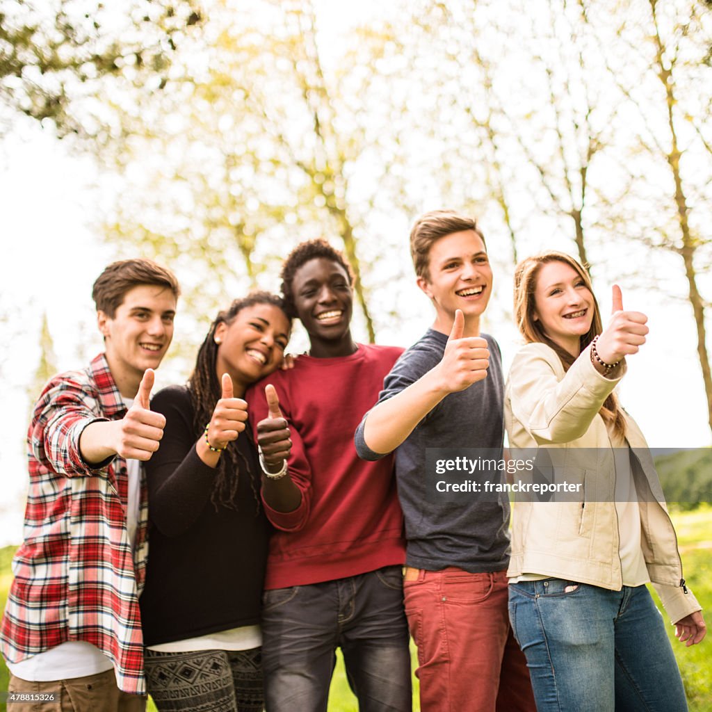 College student multiracial thumbs up at dusk