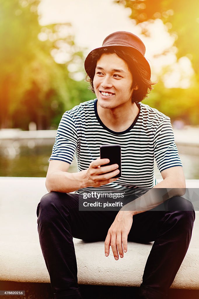 Smiling japanese teenager with smart phone