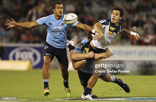 Matt Toomua of the Brumbies off loads during the round five Super Rugby match between the Brumbies and the Waratahs at GIO Stadium on March 15, 2014...