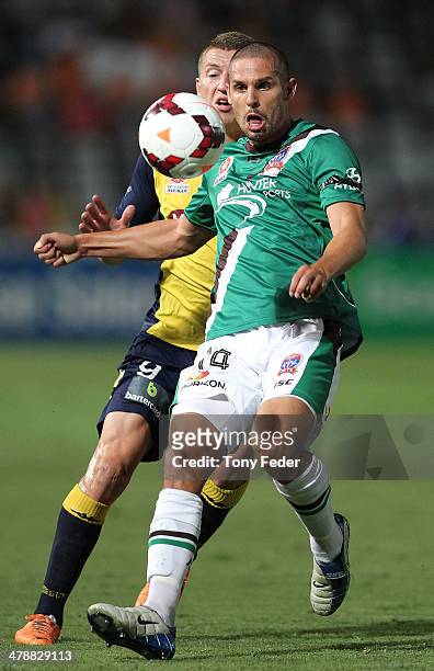 Josh Mitchell of the Jets controls the ball in front of Mitchell Duke of the Mariners during the round 23 A-League match between the Central Coast...