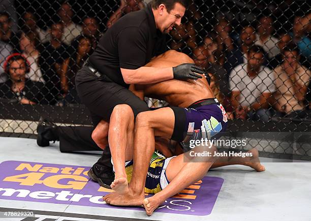 Referee John McCarthy stops Yoel Romero of Cuba from landing punches to the head of Lyoto Machida of Brazil in their middleweight during the UFC...