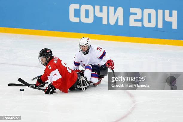 Tyler McGregor of Canada is tackled by Martin Hamre of Norway during the Ice Sledge Hockey Bronze Medal match between Canada and Norway at the Shayba...