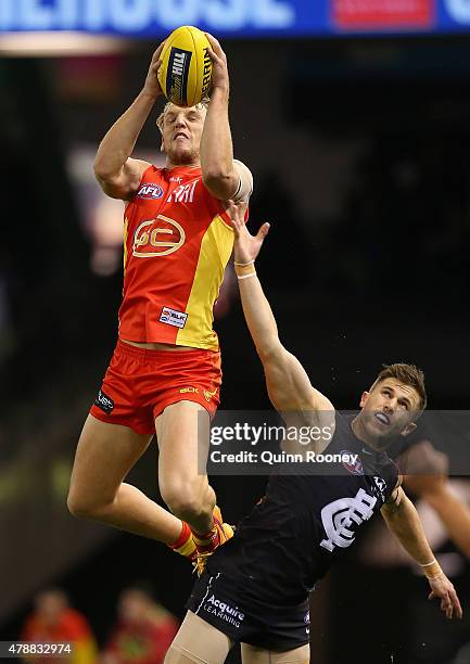 Trent McKenzie of the Suns marks over the top of Marc Murphy of the Blues during the round 13 AFL match between the Carlton Blues and the Gold Coast...
