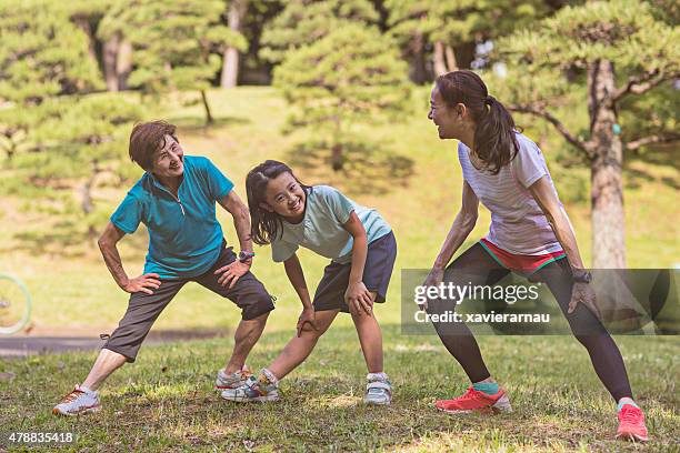 senior women with litlle girl stretching in yoyogi park - 3 old men jogging stockfoto's en -beelden