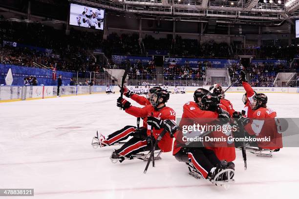 Canada players celebrate after the ice sledge hockey bronze medal game between Canada and Norway at the Shayba Arena during day eight of the 2014...