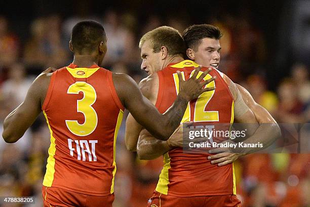 Sam Day of the Suns celebrates with team mates after kicking goal during the round one AFL match between the Gold Coast Suns and the Richmond Tigers...