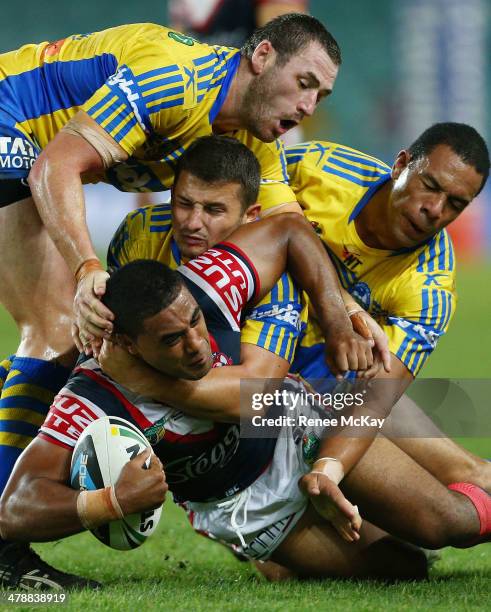 Michael Jennings of the Roosters is tackled by Luke Kelly, Ben Smith and Will Hopoate during the round two NRL match between the Sydney Roosters and...