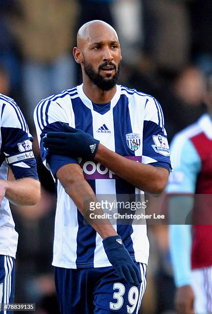 Nicolas Anelka of West Brom touches his sleeve as he celebrates scoring their first goal during the Barclays Premier League match between West Ham...
