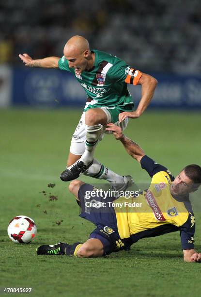 Ruben Zadkovich of the Jets leaps over the top of Nick Montgomery of the Mariners during the round 23 A-League match between the Central Coast...