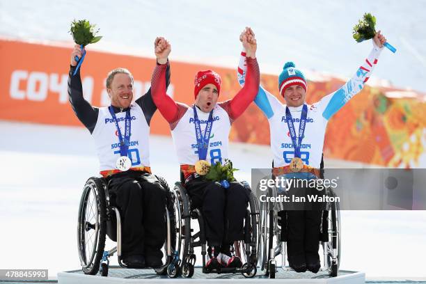 Christoph Kunz of Switzerland celebrates winning the gold medal with silver medalist Corey Peters of New Zealand and bronze medalist Roman Rabl of...