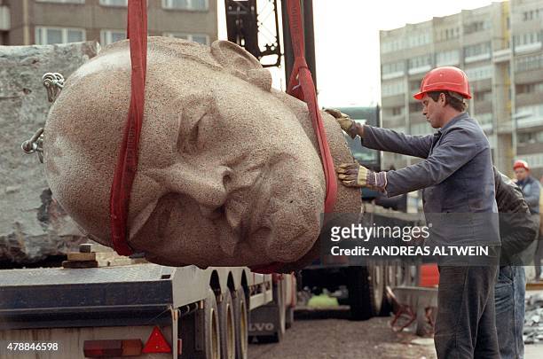 Photo dated November 13 shows a worker removing the head of a statue representing late Soviet leader Vladimir Ilyich Lenin during its demolition on...