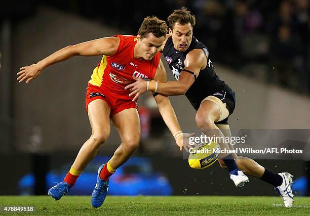 Kade Kolodjashnij of the Suns and David Ellard of the Blues in action during the 2015 AFL round thirteen match between the Carlton Blues and the Gold...