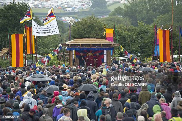 The Dalai Lama addresses an audience near the Stone Circle as he visits the Glastonbury Festival of Music and Performing Arts on Worthy Farm near the...