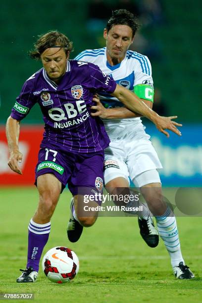 Chris Harold of the Glory holds off Mark Milligan of the Victory during the round 23 A-League match between Perth Glory and Melbourne Victory at nib...