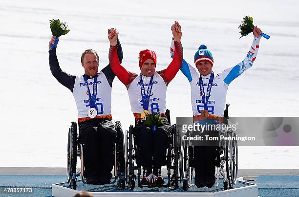 Christoph Kunz of Switzerland celebrates winning the gold medal with silver medalist Corey Peters of New Zealand and bronze medalist Roman Rabl of...