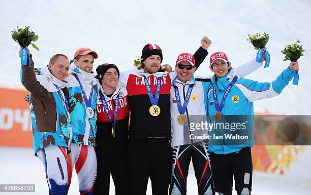Gold medalist Mac Marcoux of Canada and guide Robin Femy celebrate with silver medalists Jakub Krako of Slovakia and guide Martin Motyka and bronze...