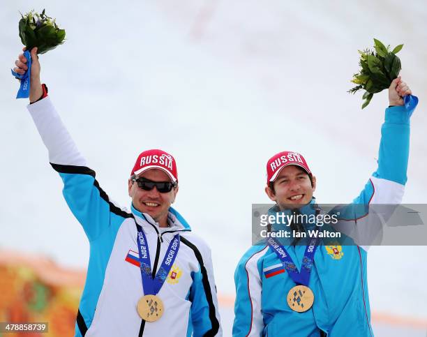 Bronze medalists Valerii Redkozubov of Russia and guide Evgeny Geroev celebrate during the medal ceremony for the Men's Giant Slalom Visually...