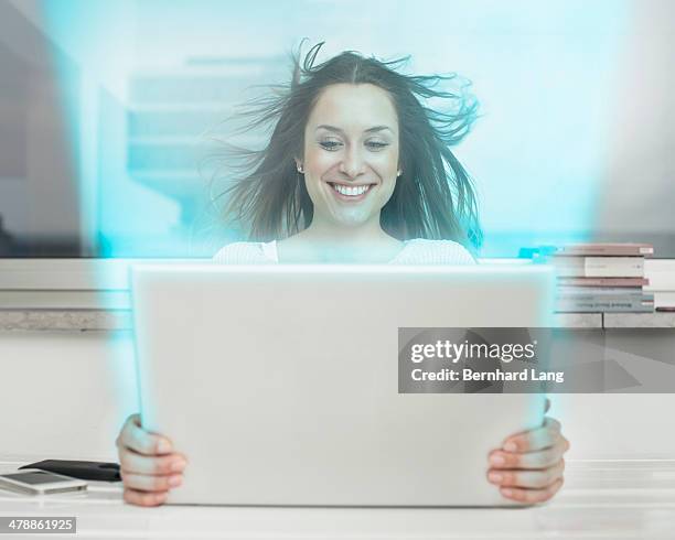 young woman looking into laptop computer, frontal - laptop frontal stock pictures, royalty-free photos & images