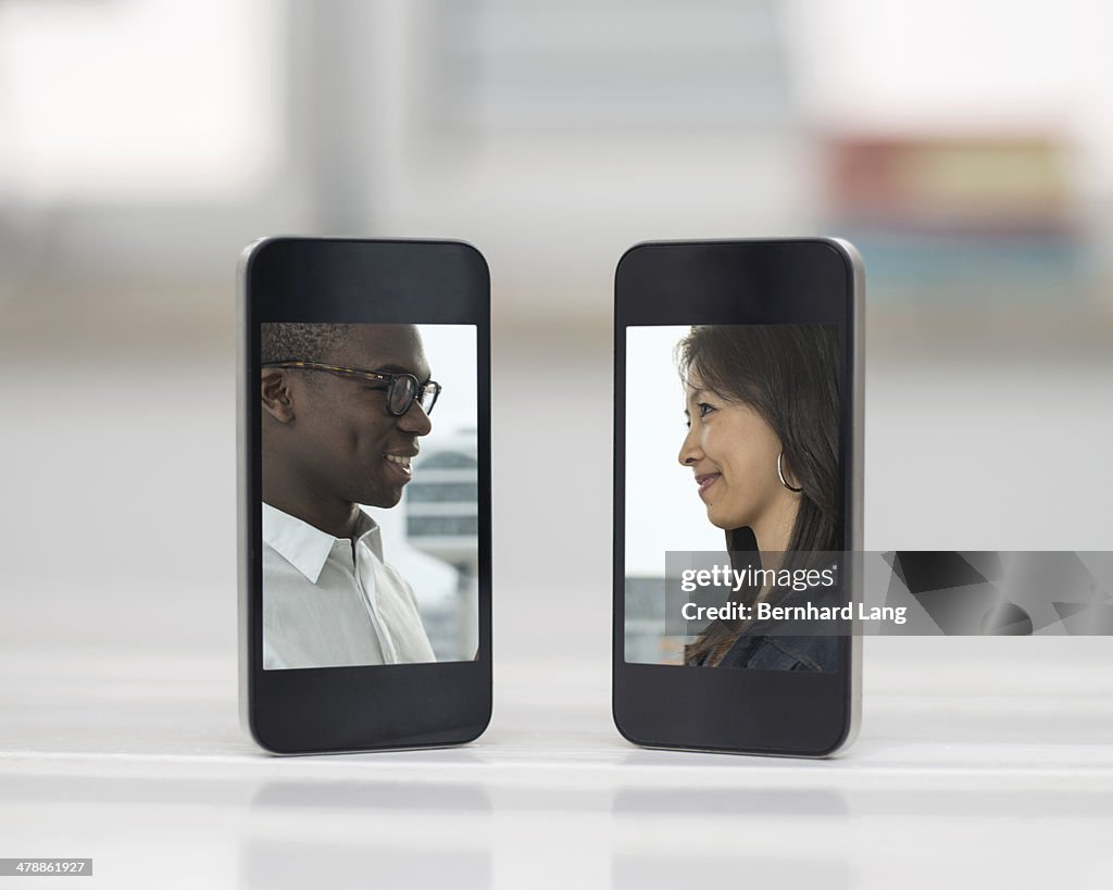 Young couple displayed on two mobile phones